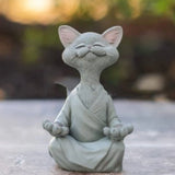 Schwarze Buddha-Katze Dekofigur im meditativen Lotussitz aus Kunstharz vor weißem Hintergrund