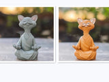 Schwarze Buddha-Katze Dekofigur im meditativen Lotussitz aus Kunstharz vor weißem Hintergrund