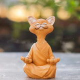 Braune Buddha-Katze Dekofigur im meditativen Lotussitz aus Kunstharz vor weißem Hintergrund