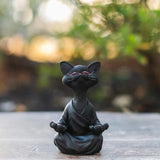 Schwarze Buddha-Katze Dekofigur im meditativen Lotussitz aus Kunstharz vor weißem Hintergrund